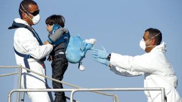 A young immigrant being moved to a rescue ship. © Darrin Zammit-Lupi
